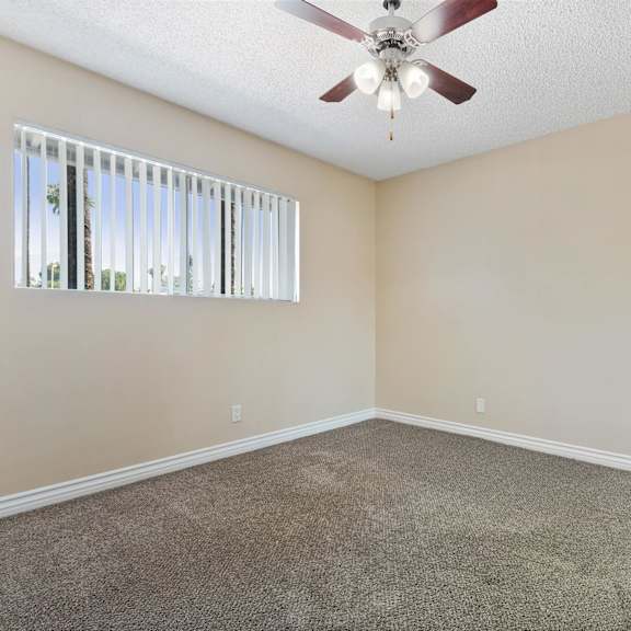 an empty living room with a ceiling fan and a window at terramonte apartment homes, pomona, ca, 91767