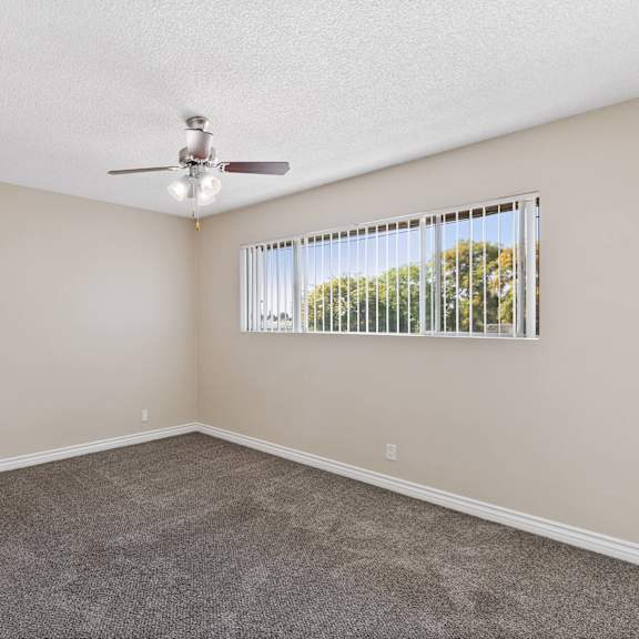 a small room with a window and ceiling fan at terramonte apartment homes, pomona, ca