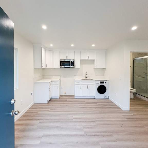 a kitchen with white cabinets and appliances is shown.