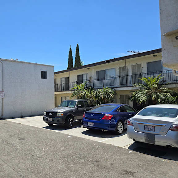 a parking lot with cars and a building in the background.