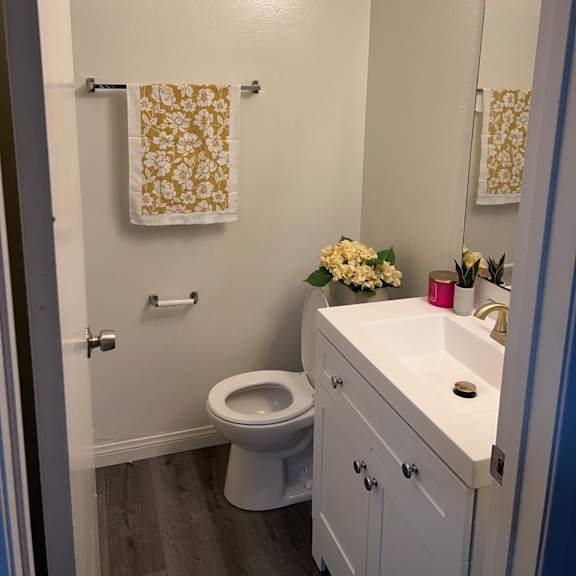 a small white bathroom with a toilet, sink, and a mirror.