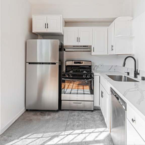 a modern kitchen with white cabinets and a stainless steel refrigerator.