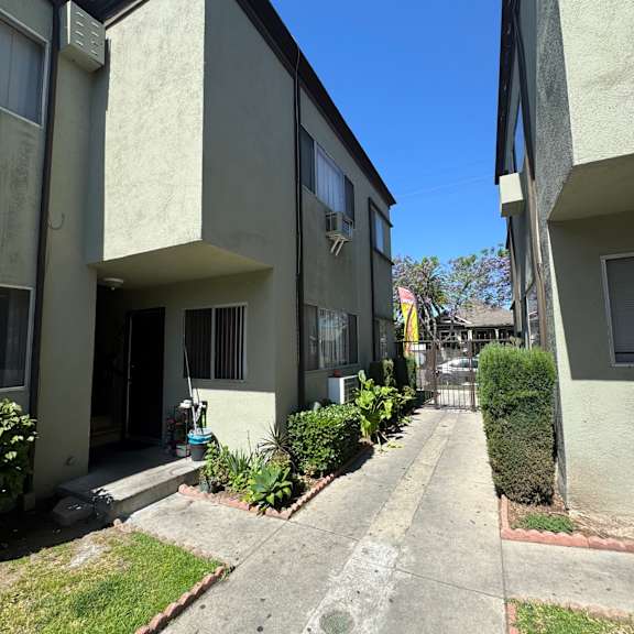 a sunny day at apartment buildings with green plants.
