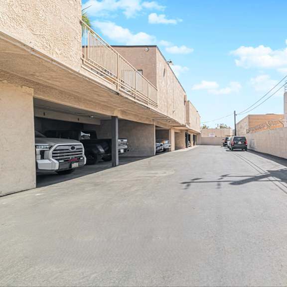 a street with cars parked on the side and buildings on both sides.