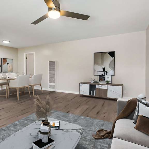a modern living room with a grey sofa, a coffee table, and a ceiling fan.