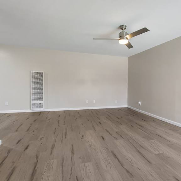 a room with a ceiling fan and light fixture, and a wall-mounted air vent.