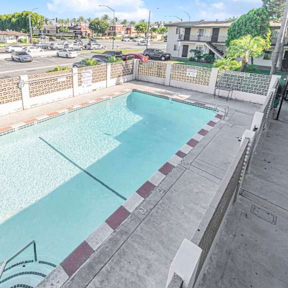 a rectangular pool with a white fence around it.