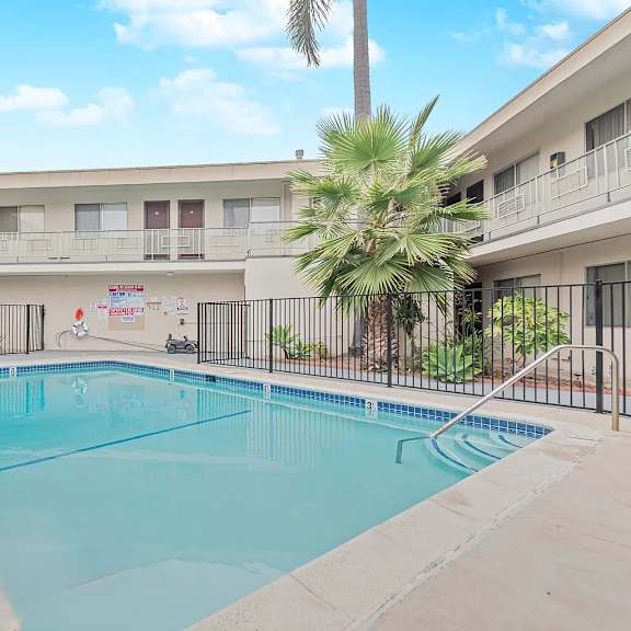 a swimming pool in a courtyard surrounded by buildings.