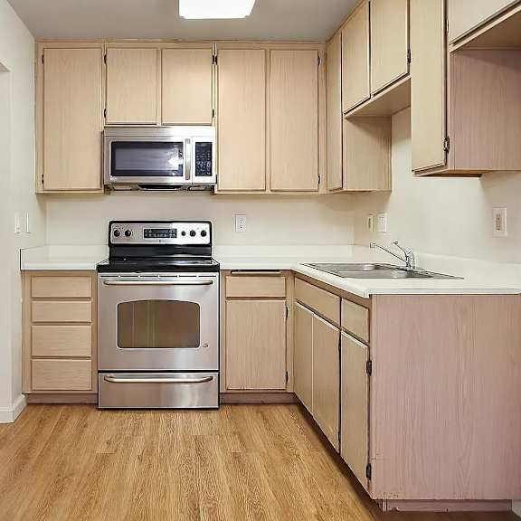 a kitchen with wooden cabinets and a stainless steel stove.