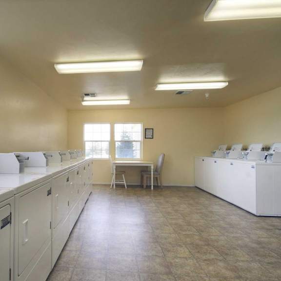 a room with white cabinets and a table with chairs.