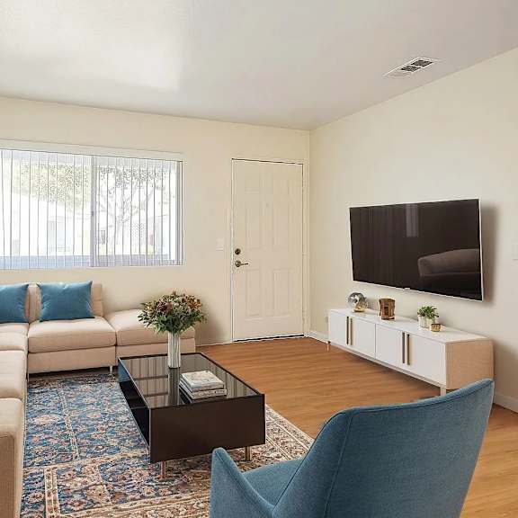 a living room with a sofa, a coffee table, a chair, and a television.