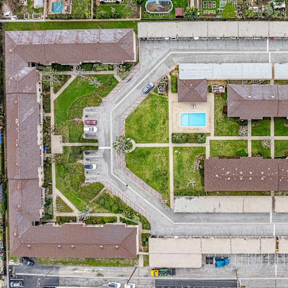 a bird's eye view of a residential area with a swimming pool and apartment buildings.