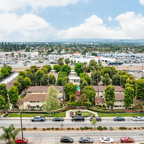 a view of a city from a high vantage point with cars on the road and buildings in the distance.