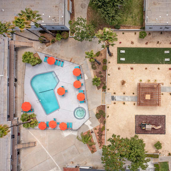 a playground with a blue slide and orange chairs.