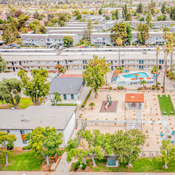 a large white building with a pool in the middle of a grassy area.