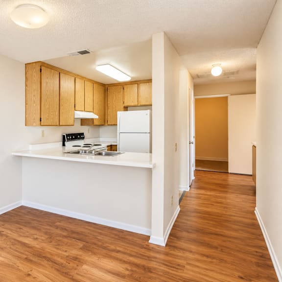 a kitchen with wooden cabinets and a white countertop.