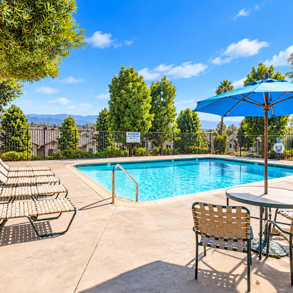 a pool area with chairs and tables is shown.