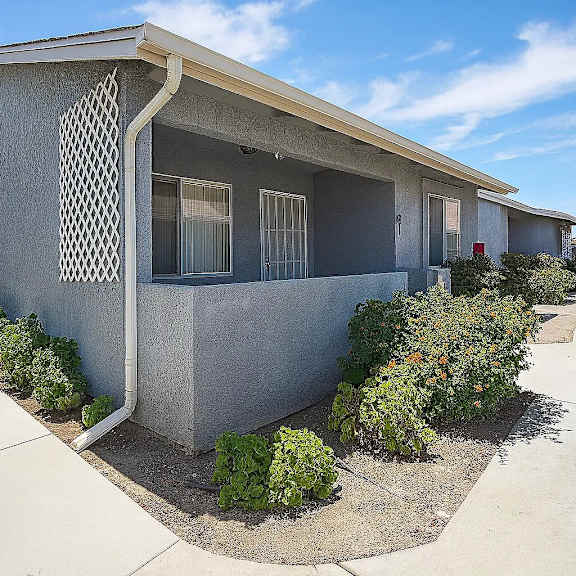 a concrete house with a concrete walkway in front.