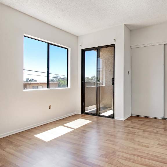 a room with a sliding glass door and a wooden floor.