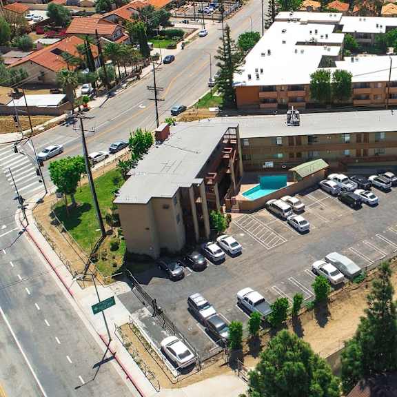 a parking lot with cars and a building in the background.
