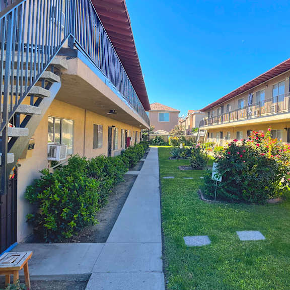 a sunny day at a residential area with apartment buildings and green lawns.
