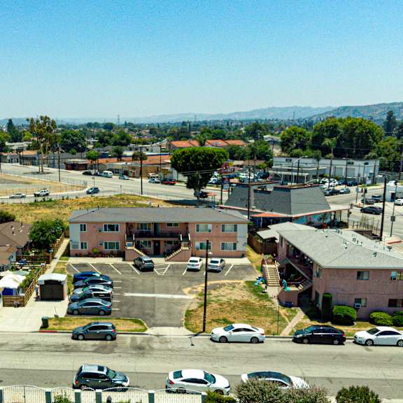 a parking lot with cars and a building in the background.