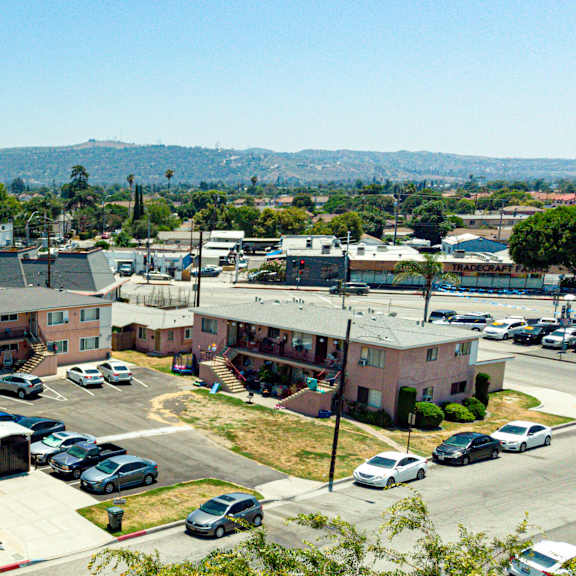 a parking lot with cars and a building in the background.