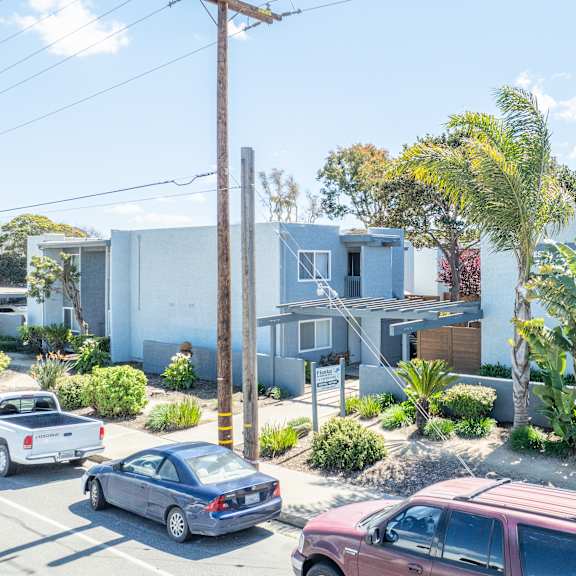 a car is parked on the street in front of a house.