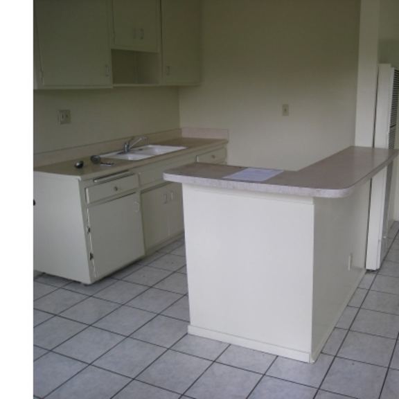 a kitchen with white appliances and a white island.