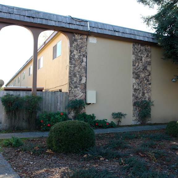 a house with a stone wall and a wooden fence.