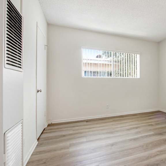 a room with a window and a wooden floor.