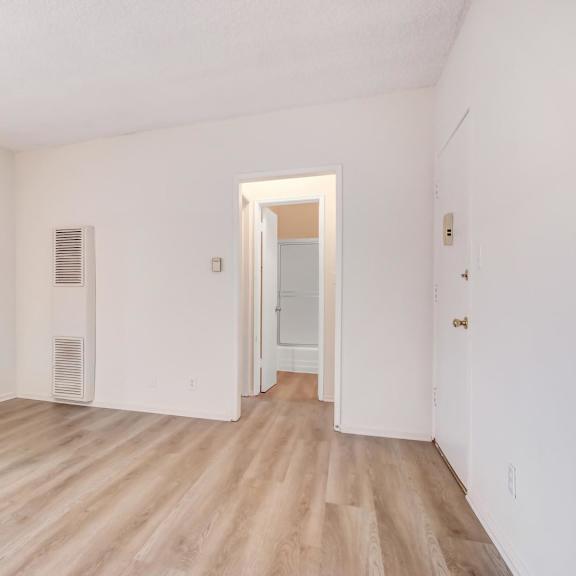 a room with a wooden floor and a door leading to another room.