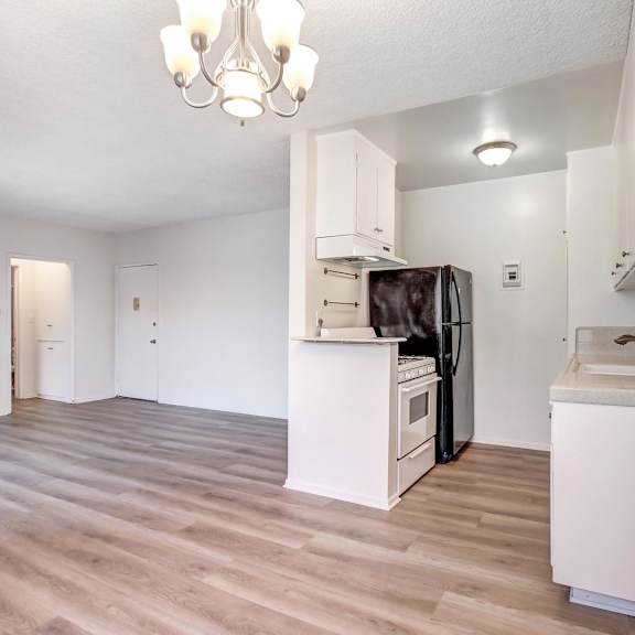 a kitchen with a refrigerator, sink, and cabinets.