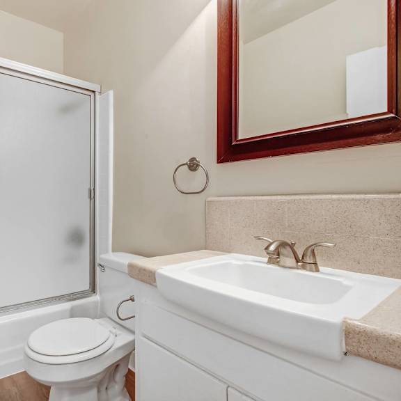 a white toilet sits next to a sink in a bathroom.
