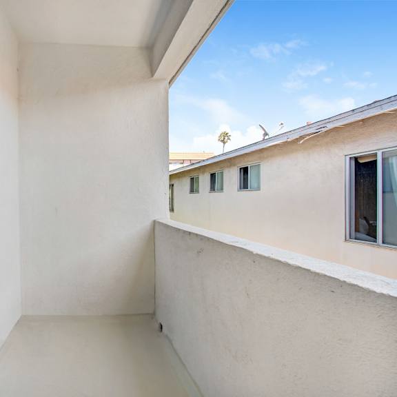 a balcony with a sliding door and a window.