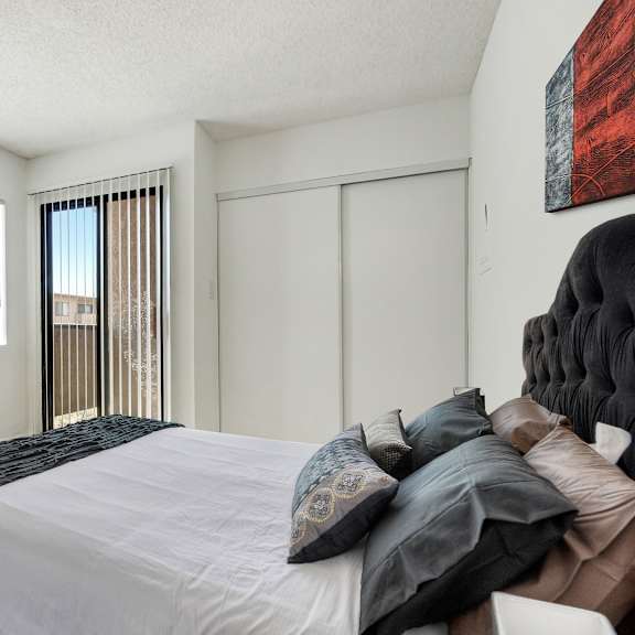 a bedroom with a large bed and a chair.