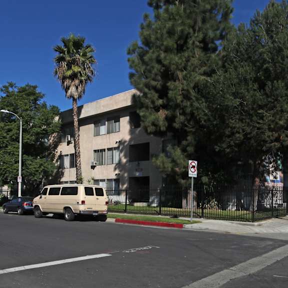 a street view with a tan van and a palm tree.