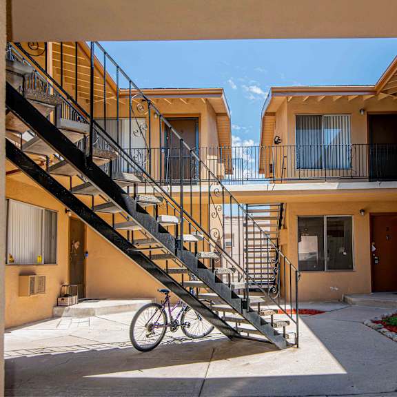 a bicycle is parked on a concrete path in front of a staircase.