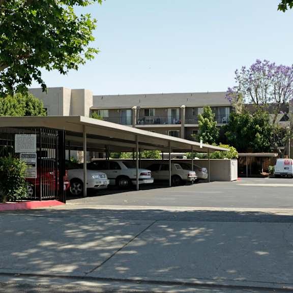 a parking lot with cars and a building in the background.