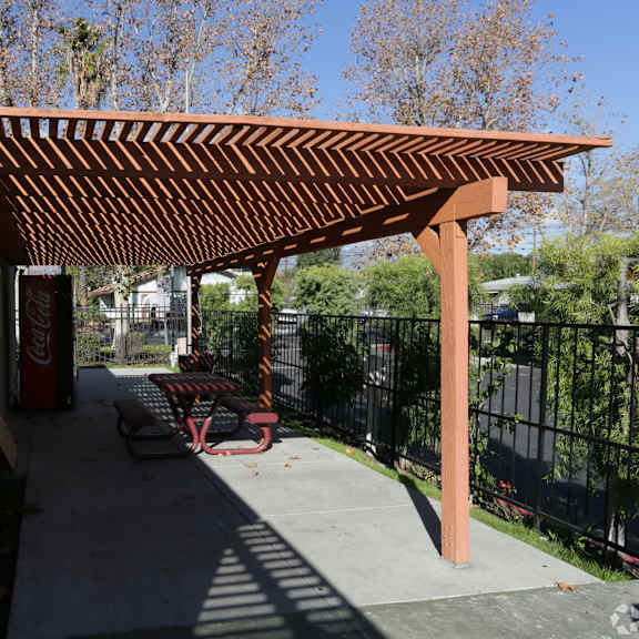 a patio with a red canopy and a coca-cola machine.