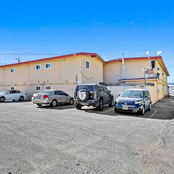 a parking lot with several cars parked in front of a building.