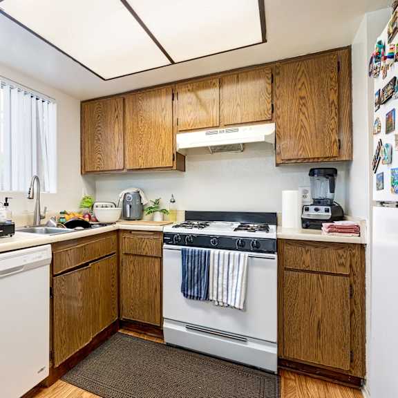 a kitchen with wooden cabinets and a white dishwasher.