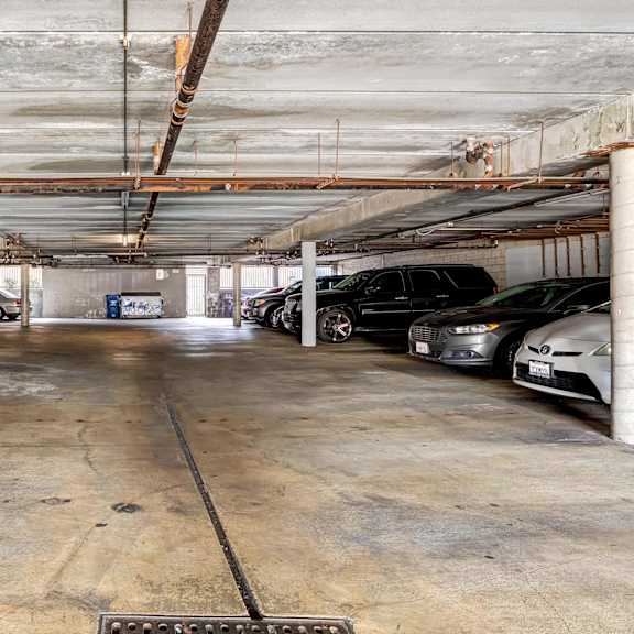 a parking garage with cars parked on the right side.