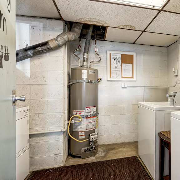 a room with a washing machine and a clock on the wall.