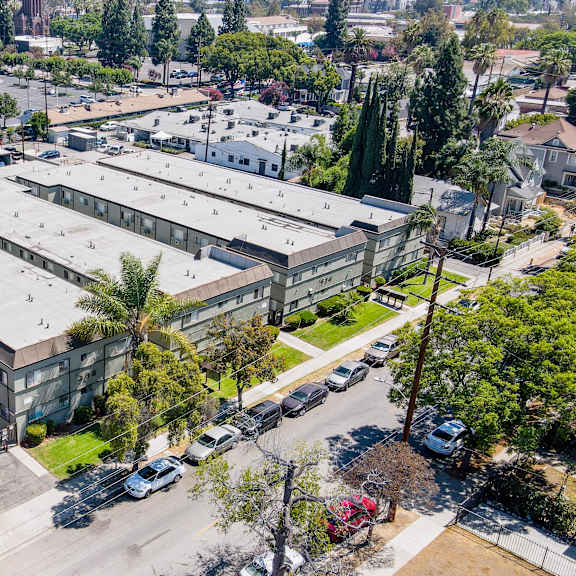a large industrial building with a parking lot in front.