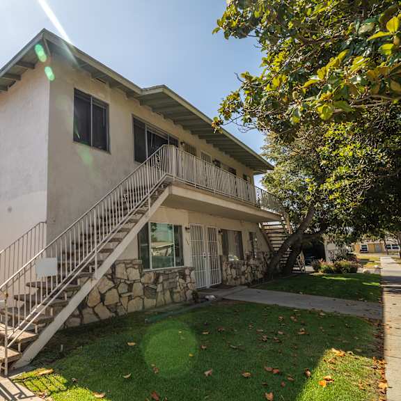 a house with a white exterior and a stone staircase leading to the front door.