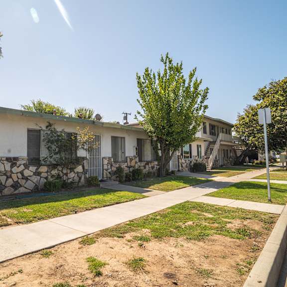 a row of houses with a stone wall in front of the first one.