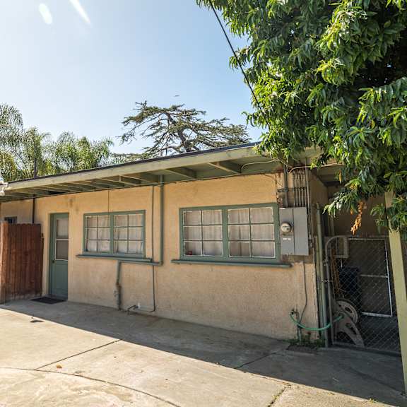 a house with a green door and a brown fence.