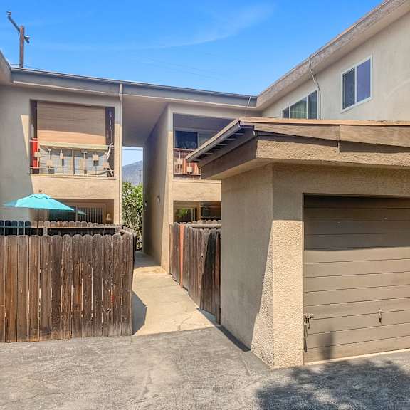 a modern house with a wooden fence and a closed garage door.