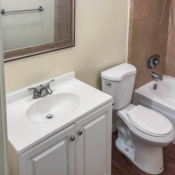 a white toilet sits next to a sink in a bathroom.